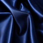 A close-up of draped satin fabric in a deep navy blue color, showing the smooth texture and sheen of the material.
