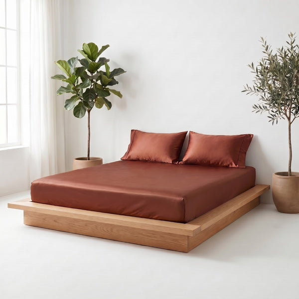 Bed with hazel bedding and wooden frame in a room with plants