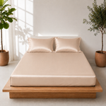 A bed with a sand color bedsheet and a green plant on the side, creating a cozy and inviting atmosphere.